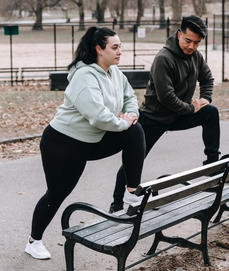A couple doing a flexibility workout at a park